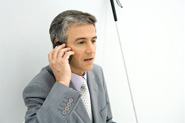Homme aveugle utilisant une canne; il est en train de discuter au téléphone.