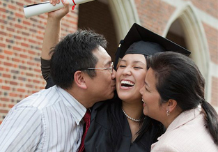 Proud parents hugging their daughter at her graduation.