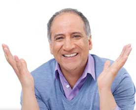 Middle-aged man is smiling with his hands in the air.