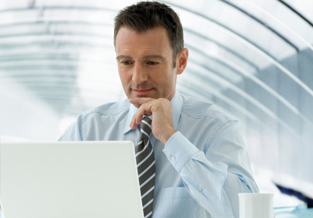 Young business man in an office reviewing his investments online.